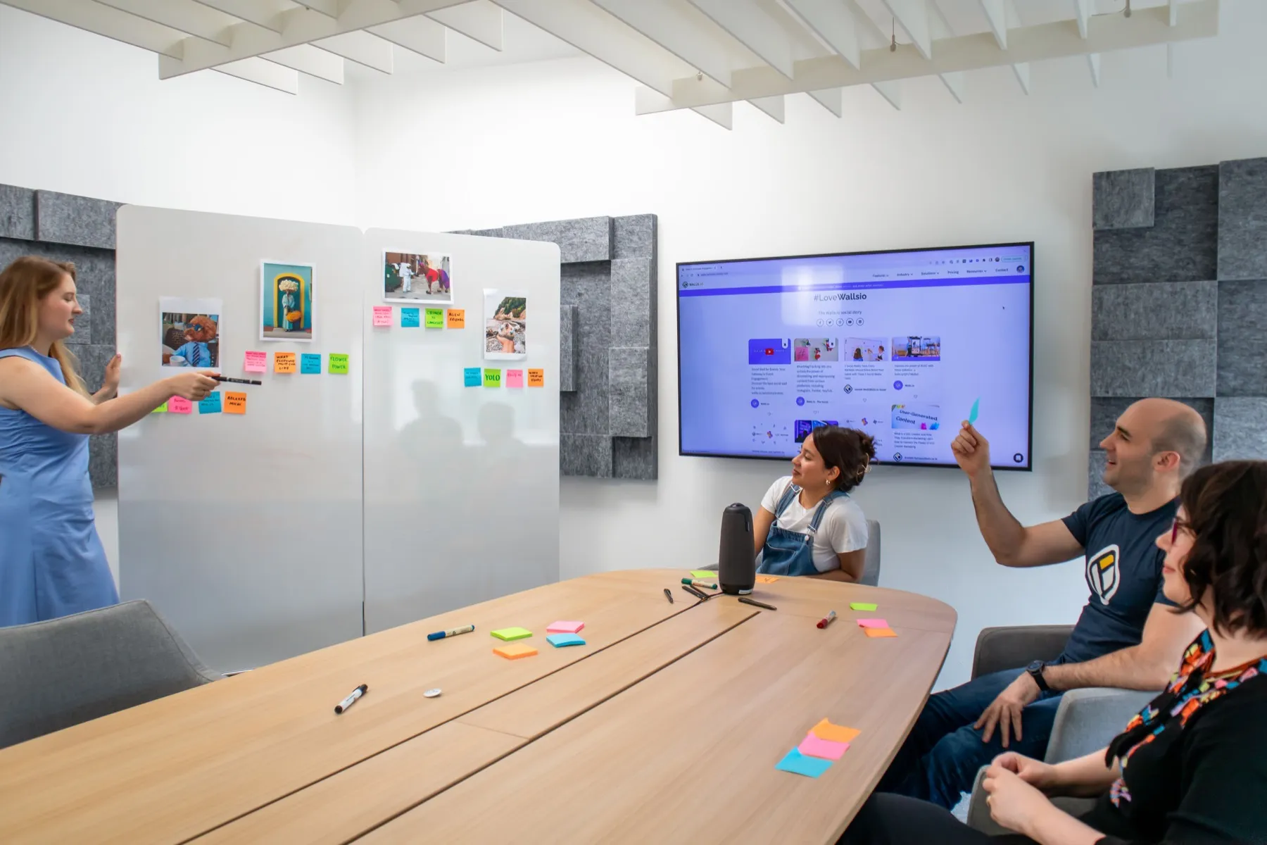 Flexus teammates collaborating around sticky notes and a digital display