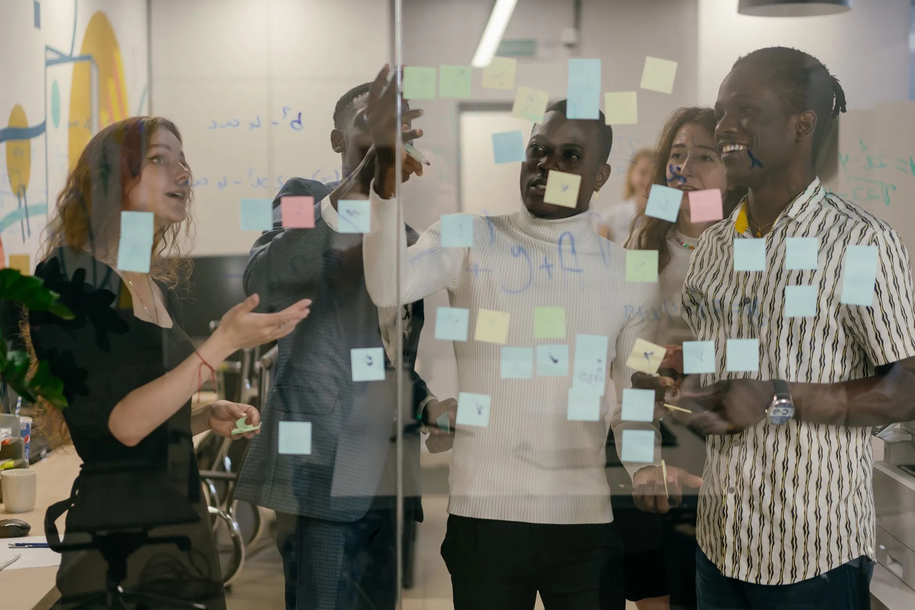 Flexus team planning client outcomes on a glass wall with sticky notes