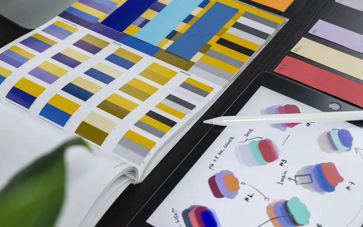 Product designer refining UI layouts and color samples at a desk