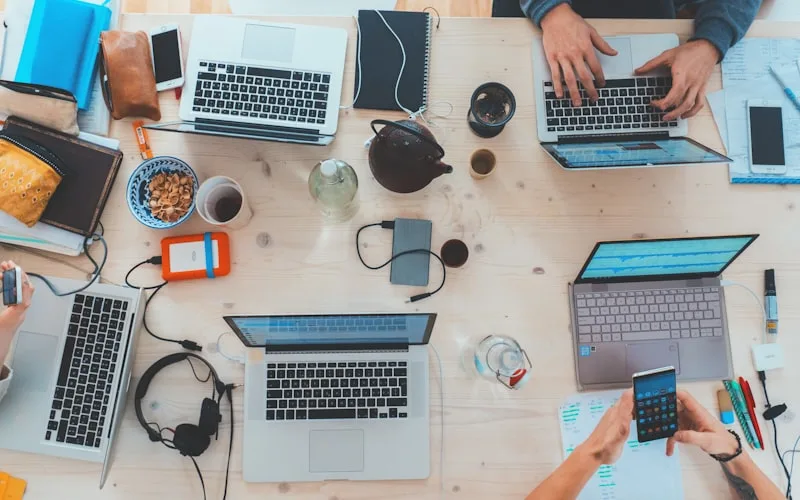 Product team collaborating around laptops on modern digital product work
