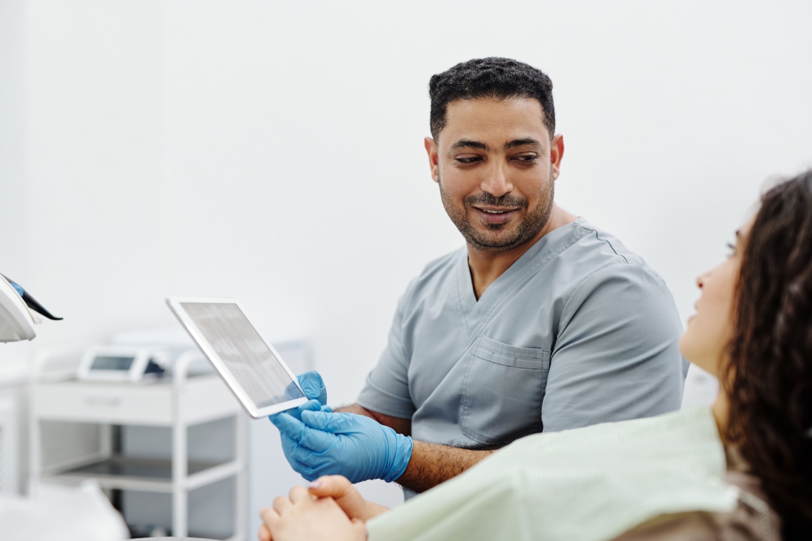 Clinician using a tablet during a patient consultation