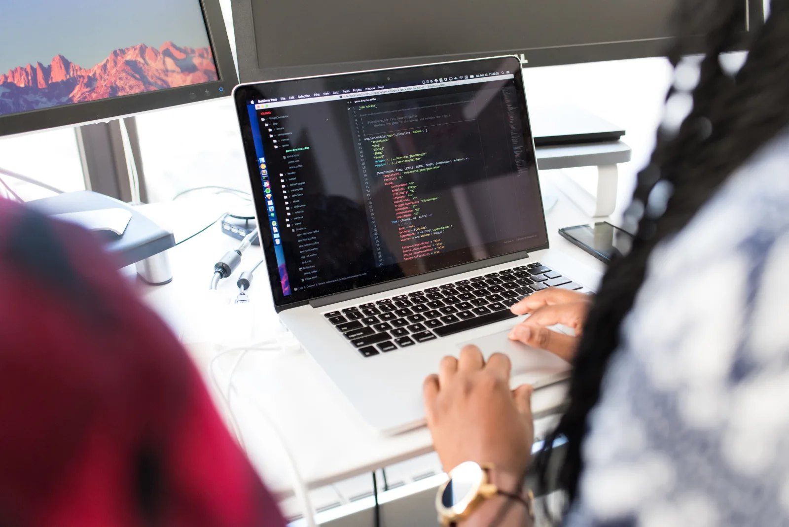 Developer building software on multi-monitor workstation