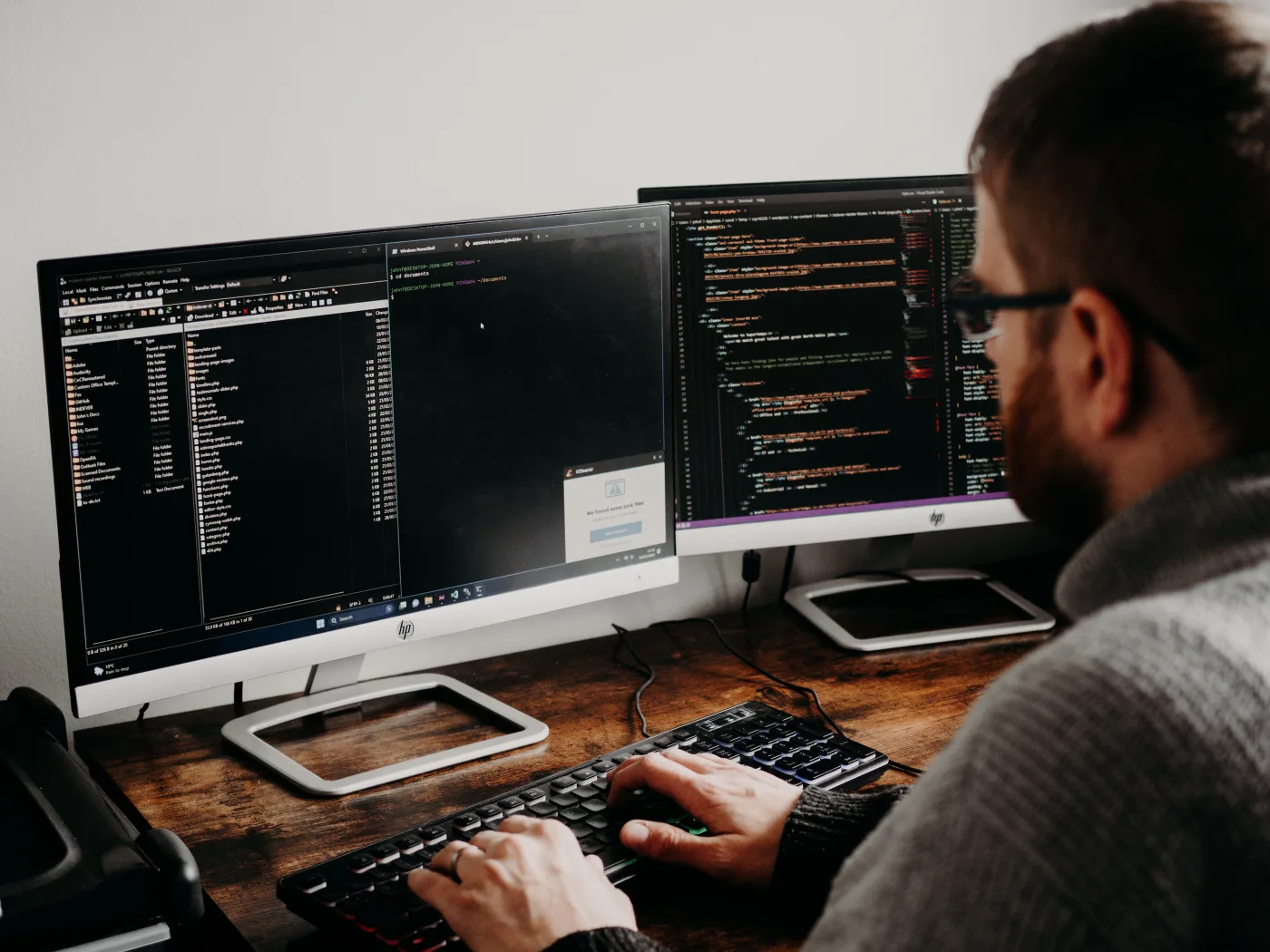 Developer writing code on dual monitors