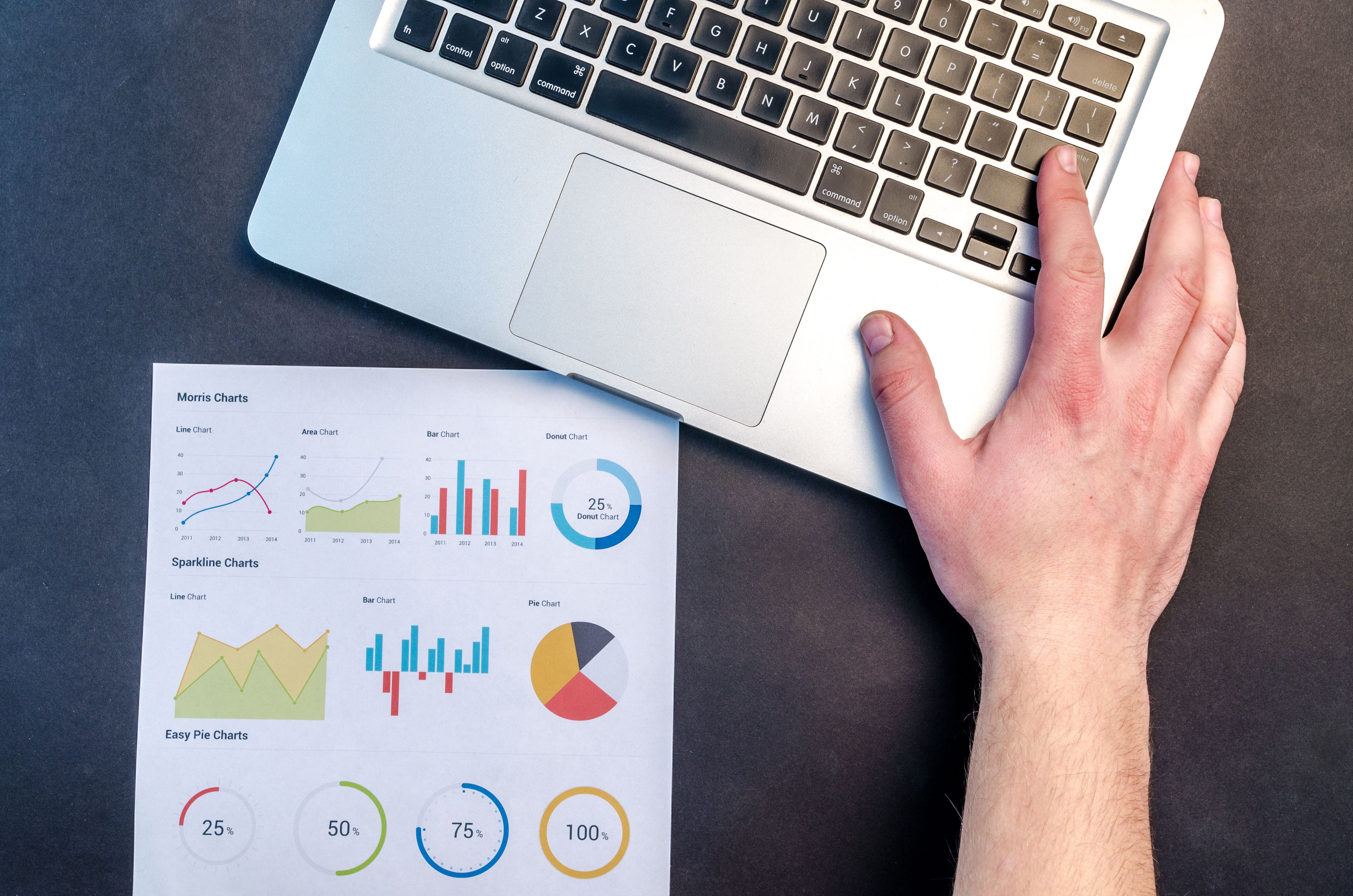 Workspace with laptop and printed analytics charts