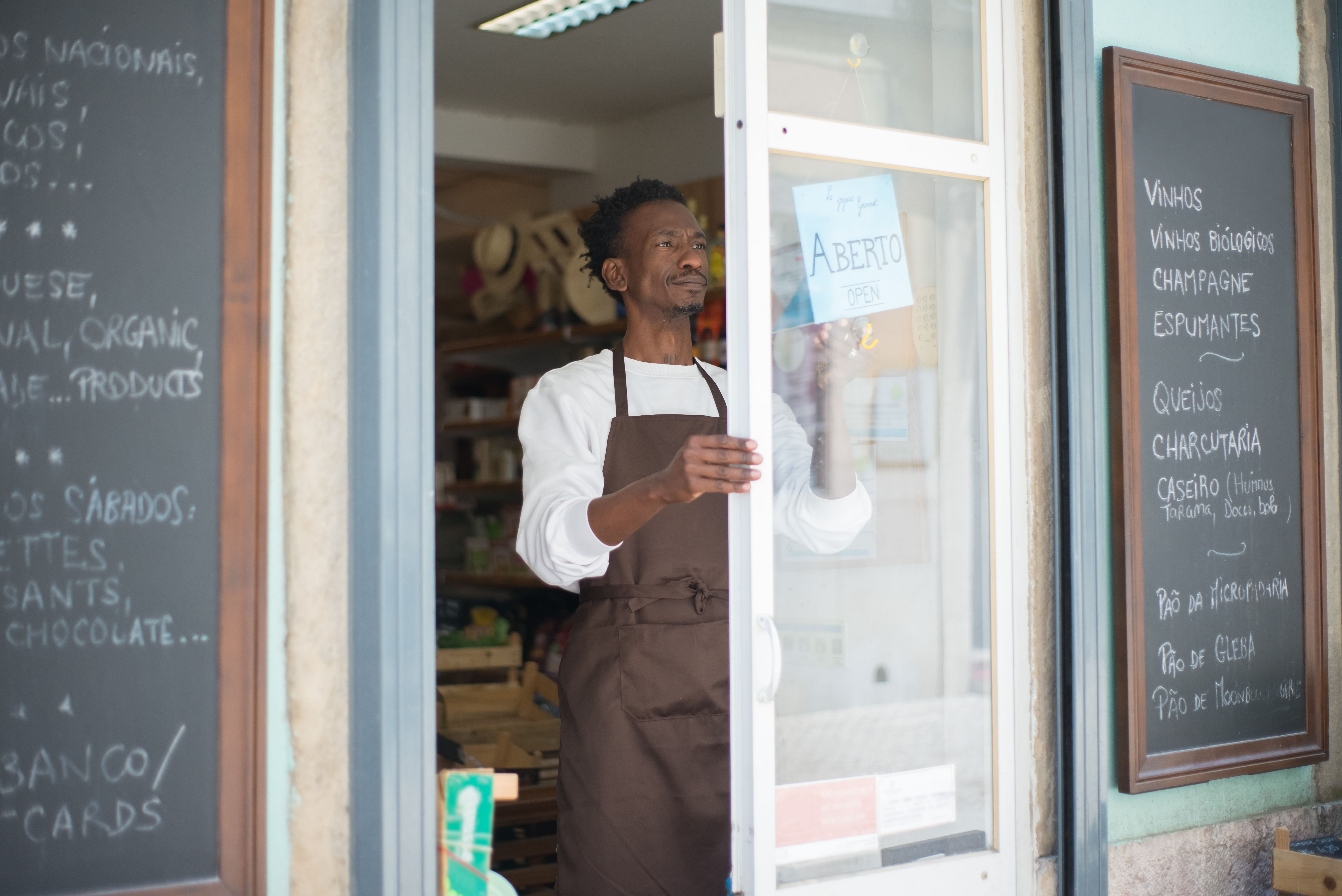 Local business owner opening the storefront to welcome customers