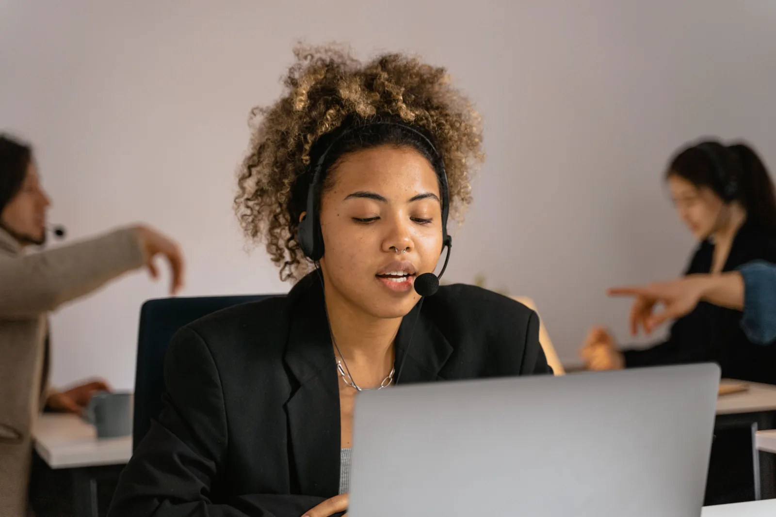 Customer support professional with headset helping a client on a laptop