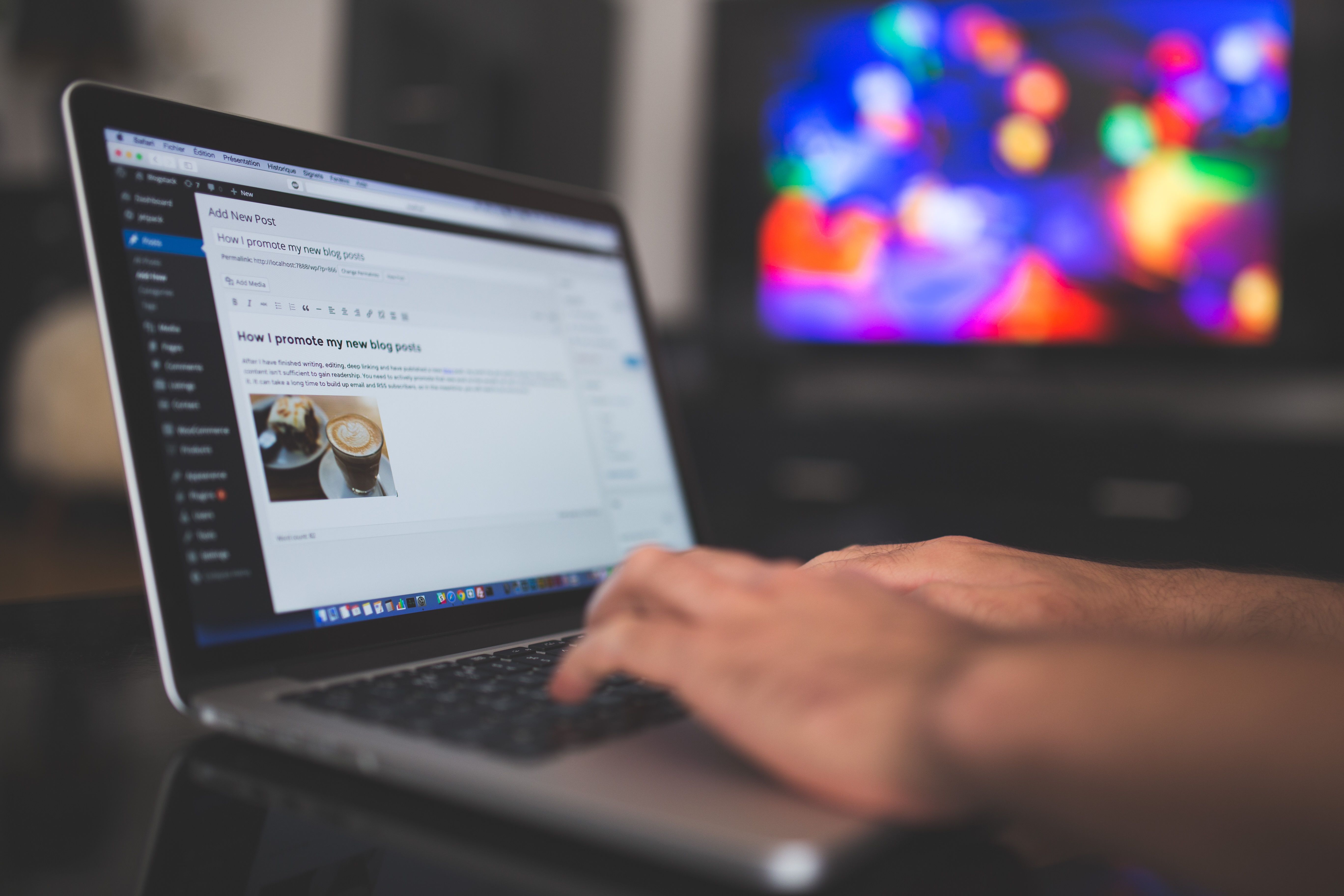 Hands typing a blog post on a laptop in a content workspace