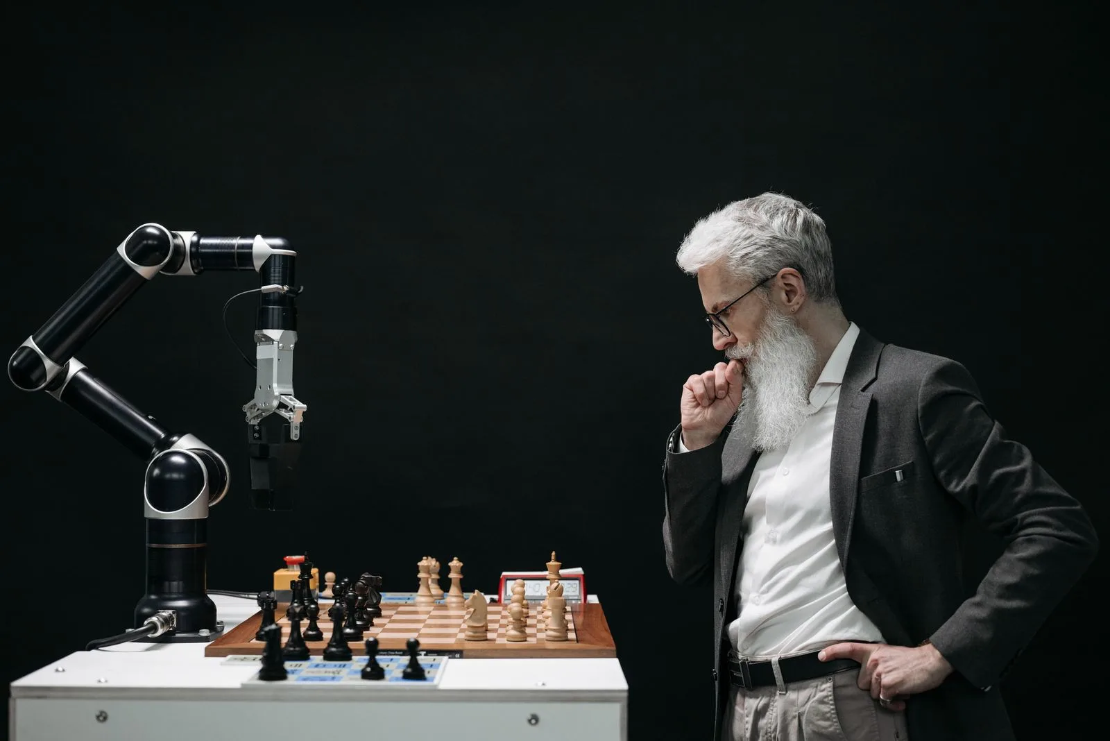 Engineer competing with a robotic arm at a chessboard — AI and automation in action